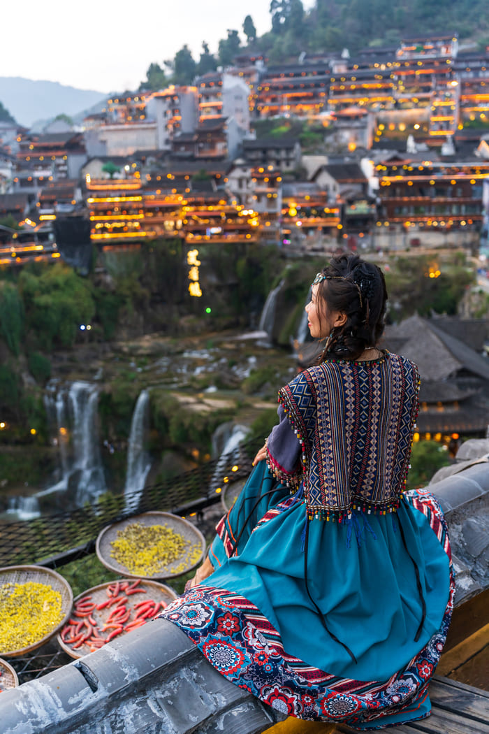 Mujer observando la ciudad lijiang sentada