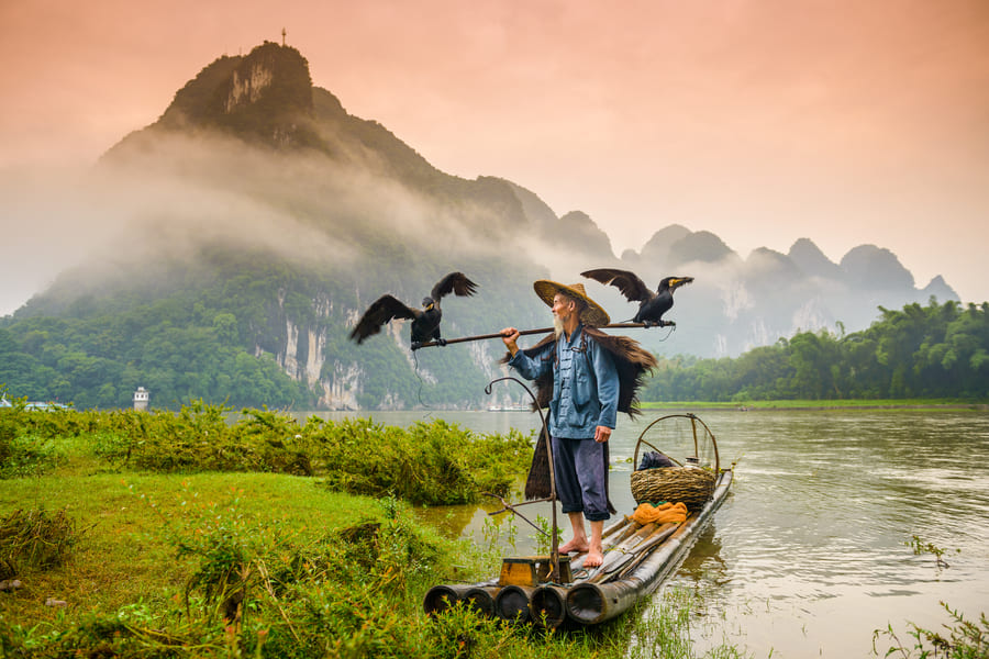 Persona en una balsa conaves en el yangshuo cormoran
